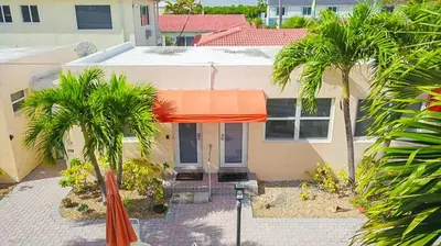 a house with two palm trees in front of it at Exclusive studio steps to the beach with pool in Hollywood