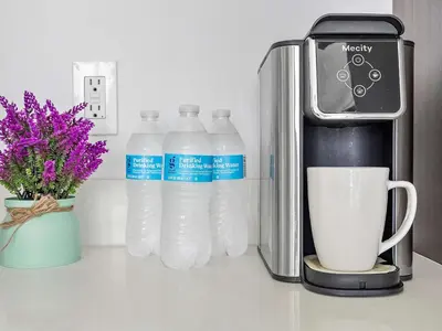 a group of bottles of water next to a coffee maker at X Lounge VIII-Prime Corner Residence in Miami
