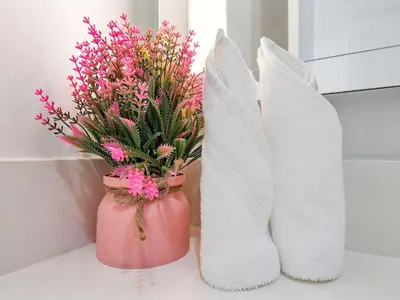a pink vase with flowers and white boots on a counter at X Lounge VIII-Prime Corner Residence in Miami