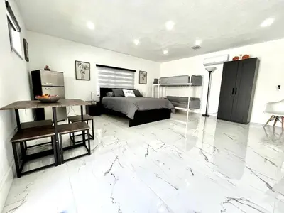 a bedroom with a bed and a large marble floor at Lovely and Private Studio