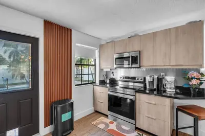 a kitchen with a stove top oven next to a window at Prized by Florida |Private Pool and HotTub Oasis| in Fort Lauderdale