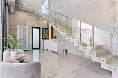 a living room with a staircase and a living room with chairs at Villa Retro Mirage in Biscayne Park