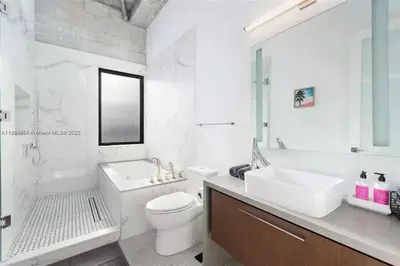 a white bathroom with a sink and a toilet at Villa Retro Mirage in Biscayne Park