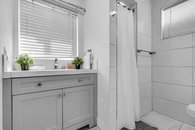 a white bathroom with a sink and a shower at Tropical Haven Cozy 1 BR Caribbean Getaway in Miami