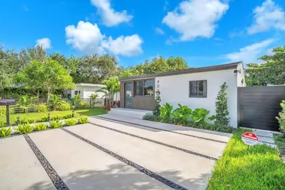 a white house with a garden and a driveway at Buena Vista Oasis - 3BR Home Near Art District Family in Miami