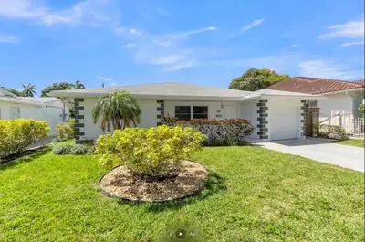 a white house with a tree in the yard at Modern Home in Hallandale Beach in Hallandale Beach