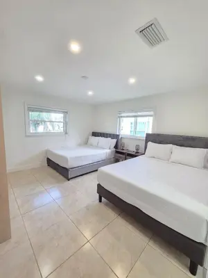a bedroom with two beds and two windows at Modern Home in Hallandale Beach in Hallandale Beach