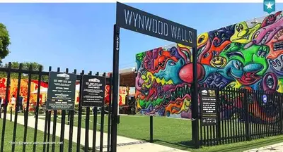 a fence with a mural on the side of a park at Stylish 1BR Modern Apt in Brickell - Free Parking in Miami