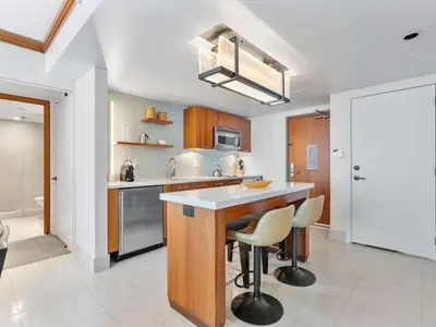 a kitchen with a island with stools in it at Villa Seafoam in Miami Beach