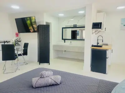 a bedroom with a bed and a bathroom with a sink at Kevin#B Chic Studio with Patio near Fort Lauderdale Beach in Fort Lauderdale