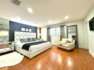 a large bedroom with a bed and a chair at The Hollywood Beach Experience in Hollywood