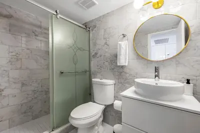 a bathroom with a toilet and a sink and a mirror at Beachfront Studio with Resort Access STR-02630 in Sunny Isles Beach
