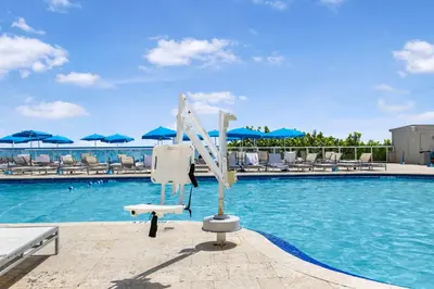a swimming pool with a lifeguard chair next to the water at Beachfront Studio with Resort Access STR-02630 in Sunny Isles Beach