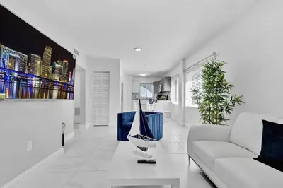 a living room with a white couch and a boat on a table at Modern 2-Bedroom Apartment in Miami