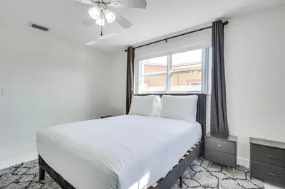 a bedroom with a large bed and a window at 3 Mi to Hard Rock Stadium Home with Fenced-In Yard! in Miramar