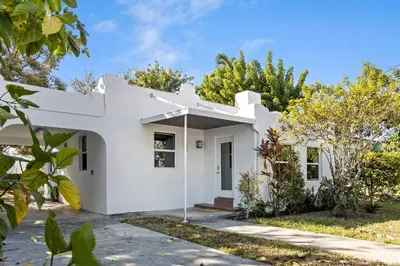 a white house with trees in front of it at Stylish 2BR/2BA Miami Home near Wynwood in Miami