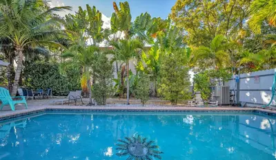 a swimming pool with palm trees in the background at The Jute Box - Pool - Waterview - Wilton Drive in Fort Lauderdale