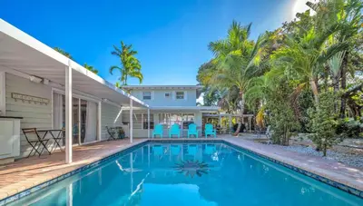 a swimming pool in front of a house with palm trees at The Jute Box - Pool - Waterview - Wilton Drive in Fort Lauderdale