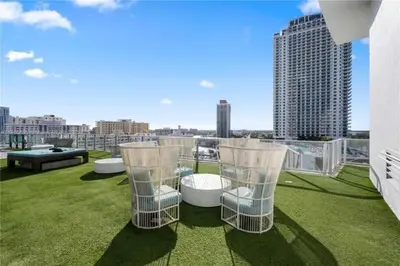 a balcony with tables and chairs on the grass at Corner Penthouse Ocean and City View in Hollywood