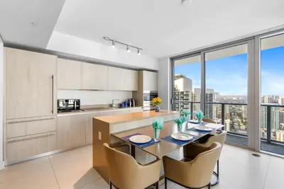 a kitchen with a table and chairs and a large window at Corner Penthouse Ocean and City View in Hollywood