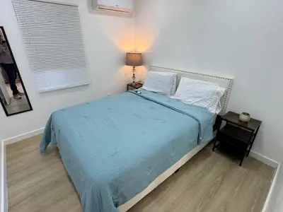 a bedroom with a bed with a blue blanket and a lamp at Comfy and Relaxed in Cutler Bay