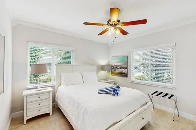 a white bedroom with a bed and a ceiling fan at The Front House in Fort Lauderdale