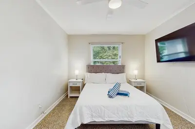 a bedroom with a bed with two night stands at The Front House & Cottage in Fort Lauderdale