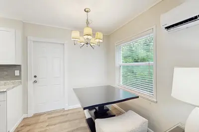 a dining room with a black table and a window at The Front House & Cottage in Fort Lauderdale