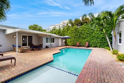 a swimming pool in front of a house at The Cottage in Fort Lauderdale