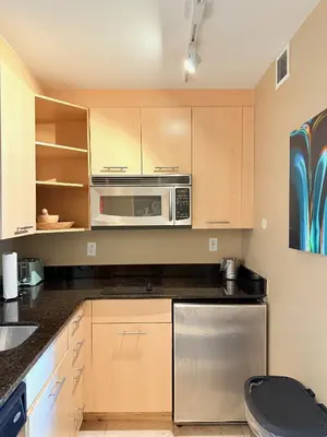 a kitchen with wooden cabinets and a microwave at Sunrise on the Intracoastal in Fort Lauderdale