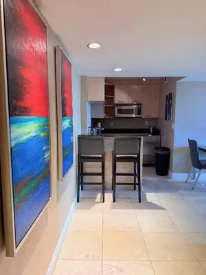 a kitchen with two chairs and a table with paintings on the wall at Sunrise on the Intracoastal in Fort Lauderdale