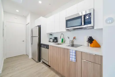 a kitchen with a stainless steel refrigerator and a microwave at Wynwood Retreat - Rooftop Pool & Neighborhood Views in Miami