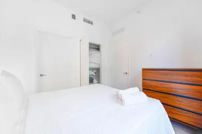 a bedroom with a white bed with a wooden headboard at Wynwood Retreat - Rooftop Pool & Neighborhood Views in Miami