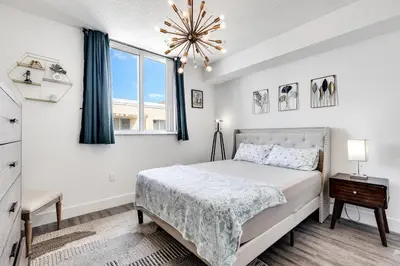 a bedroom with a bed and a window and a chandelier at 1 Bedroom Apt With Patio in South Riverside in Miami