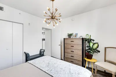 a bedroom with a bed and a chandelier at 1 Bedroom Apt With Patio in South Riverside in Miami