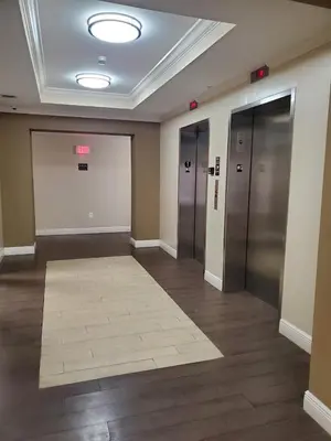a hallway with elevators and a rug in a building at 1 Bedroom Apt With Patio in South Riverside in Miami