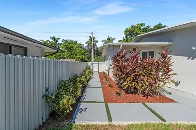 a house with a fence and a sidewalk at RJ Home Away From Home LLC in Miami Gardens