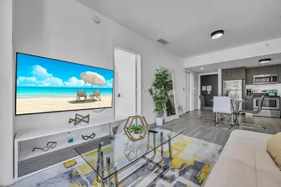 a living room with a large flat screen tv on a wall at Waterline Corner Vies 2Br 2BA Suites in Miami