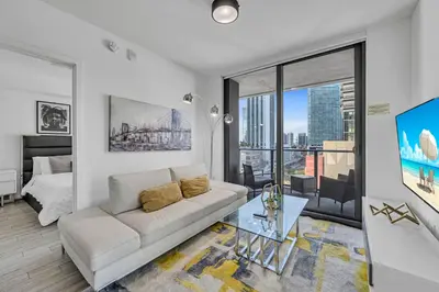 a white living room with a couch and a bed at Waterline Corner Vies 2Br 2BA Suites in Miami