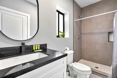 a bathroom with a sink and a toilet and a mirror at Central Miami Studio - Wynwood 8 Min in Miami