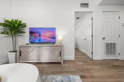 a living room with a flat screen tv on a dresser at Cozy By The Blue in Miami