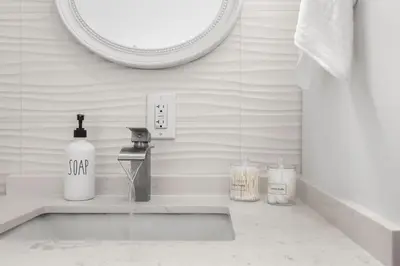 a bathroom sink with a soap dispenser and a mirror at Cozy By The Blue in Miami