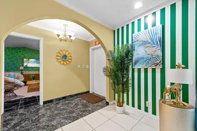 a hallway with a green and white striped wall at Large 12 Guest Home w Pool, Hollywood FL in Hollywood