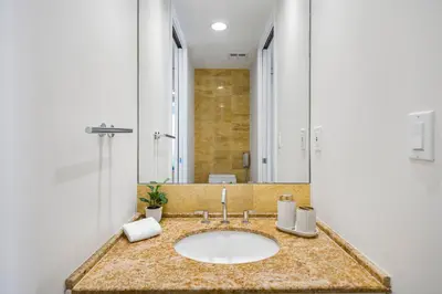 a bathroom with a sink and a large mirror at City View Condo in the Heart of Brickell in Miami