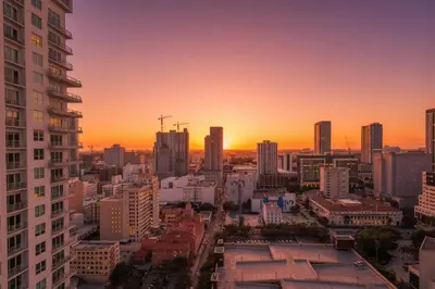 a city skyline with a sunset in the background at Contemporary Comfort Rooftop Views & Full Kitchen in Miami