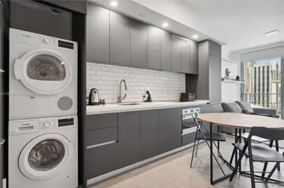 a kitchen with a washer and dryer and a table at Skyline Nomad Studio Walk to Kaseya Rooftop Pool in Miami