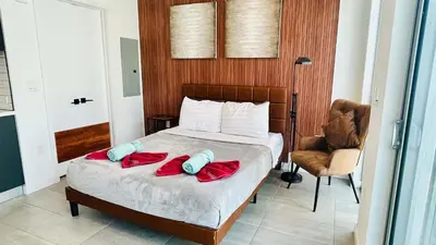 a bedroom with a bed with red sheets and a chair at Skyline Studio Workspace & Rooftop Pool in Miami