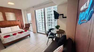 a bedroom with a bed and a table and a balcony at Skyline Studio Workspace & Rooftop Pool in Miami