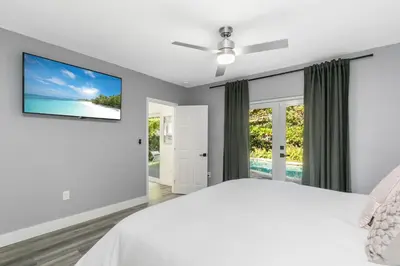 a bedroom with a bed and a flat screen tv at Modern Miami Oasis with Pool & Water View in North Miami
