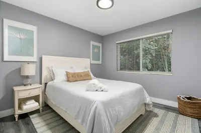 a bedroom with a white bed and a window at Modern Miami Oasis with Pool & Water View in North Miami